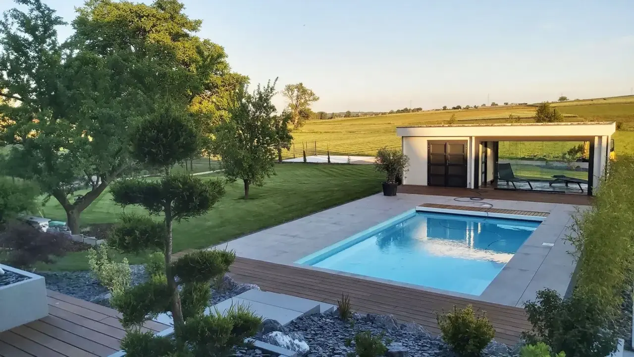 Magnifique jardin avec piscine, pelouse impeccable, arbres taillés et une petite maison moderne. Un havre de paix.