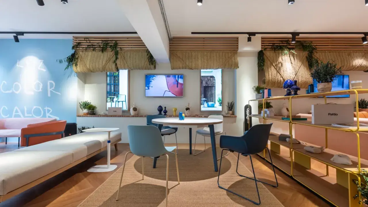 Ambiance lumineuse et colorée pour une idée décoration bureau professionnel. Canapés, table ronde, étagères et plantes créent un espace accueillant.