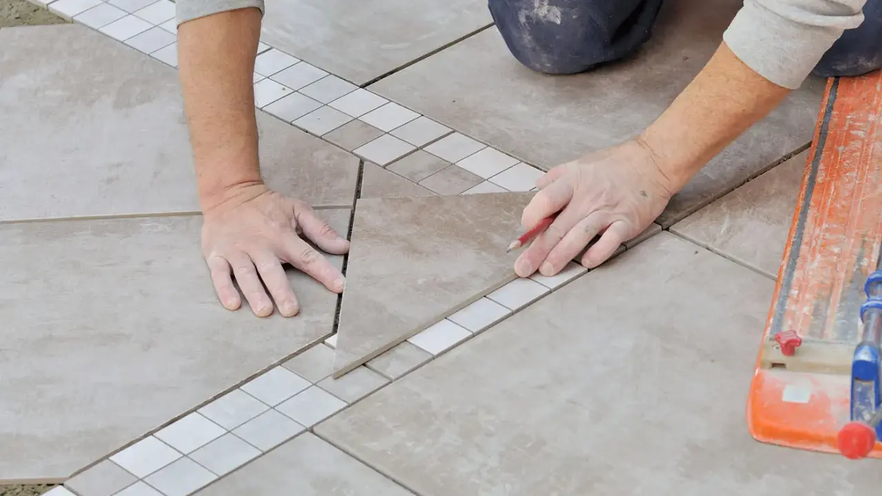 Mains expertes pour carreler une terrasse, posant une nouvelle dalle avec précision.