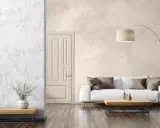 Salon moderne avec un canapé blanc, une table basse en bois et un grand pot de fleurs. Le mur de fond présente un bel **effet enduit décoratif** texturé.