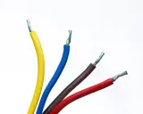 Faisceau de fils électriques colorés : jaune, bleu, marron et rouge. Un fil noir est caché parmi eux, prêt à transporter l'électricité.