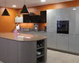 Aménagement d'une cuisine moderne avec îlot central et meubles gris laqué. Une **conception cuisine 3D** qui inspire.