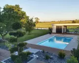 Magnifique jardin avec piscine, pelouse impeccable, arbres taillés et une petite maison moderne. Un havre de paix.