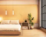 Une chambre style japonais épurée avec un lit bas en bois, des coussins douillets, des plantes vertes et une fenêtre aux persiennes sombres.