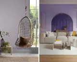 Un fauteuil suspendu en rotin et un salon moderne aux murs couleur parme clair.