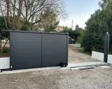 Emplacement moteur portail coulissant installé sur une nouvelle installation. Le portail est gris anthracite, moderne.