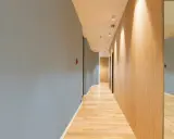 Couloir moderne avec un mur bleu texturé, un mur en bois clair et un sol en parquet. Le mur de gauche, en fibre de verre, est d'un bleu doux.