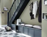 Escalier moderne avec une couleur tendance, banc de rangement gris, porte d'entrée noire et sol à motifs.
