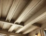 Plafond en bois avec poutres peintes couleur lin, créant une ambiance chaleureuse et rustique.