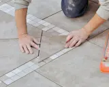 Mains expertes pour carreler une terrasse, posant une nouvelle dalle avec précision.