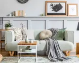 Un plaid gris drapé sur un canapé vert menthe, ajoutant une touche cosy. Idée pour comment mettre un plaid sur un canapé avec style.