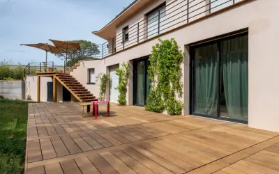 Grande terrasse en bois, une dalle terrasse directement sur terre, menant à un escalier extérieur.