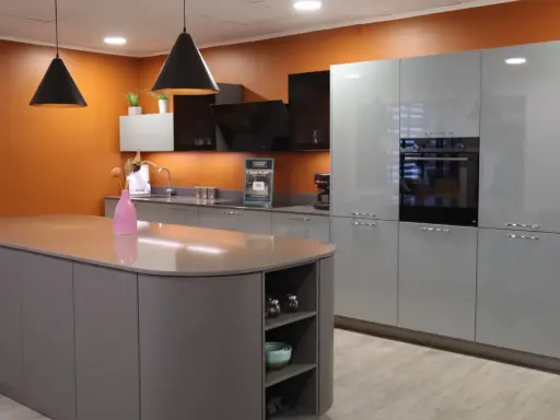 Aménagement d'une cuisine moderne avec îlot central et meubles gris laqué. Une **conception cuisine 3D** qui inspire.