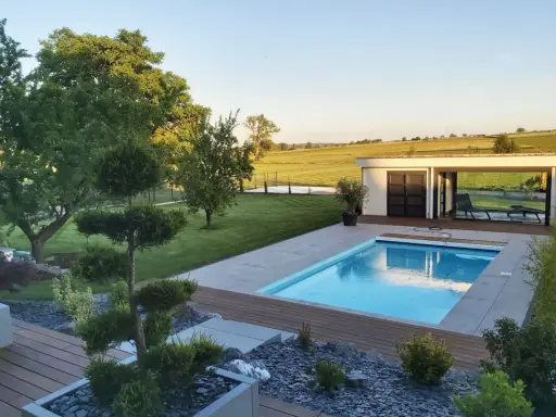 Magnifique jardin avec piscine, pelouse impeccable, arbres taillés et une petite maison moderne. Un havre de paix.