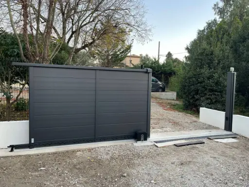 Emplacement moteur portail coulissant installé sur une nouvelle installation. Le portail est gris anthracite, moderne.