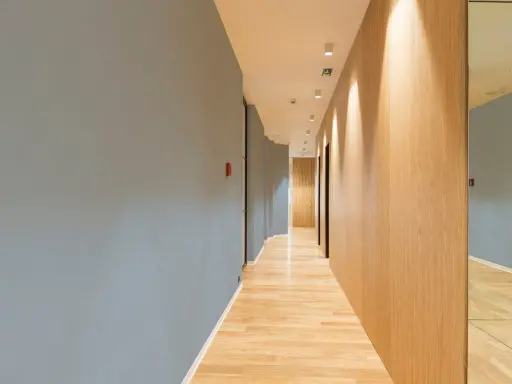 Couloir moderne avec un mur bleu texturé, un mur en bois clair et un sol en parquet. Le mur de gauche, en fibre de verre, est d'un bleu doux.