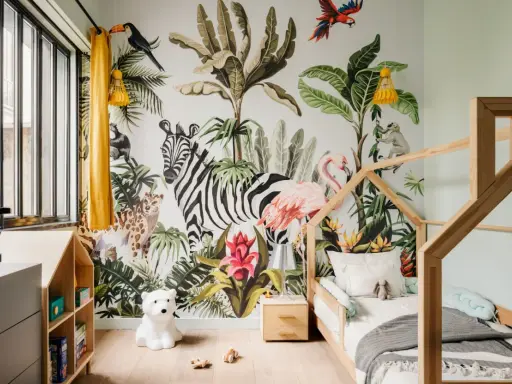 Une chambre d'enfant avec un mur jungle : zèbre, flamant rose, léopard, singe, toucan. Une excellente idée déco chambre enfant pour l'aventure !