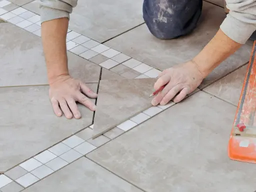 Mains expertes pour carreler une terrasse, posant une nouvelle dalle avec précision.