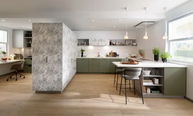Une cuisine moderne avec des armoires vert sauge et un mur à motifs floraux. La peinture salle à manger 2 couleurs crée un espace chaleureux et invitant.