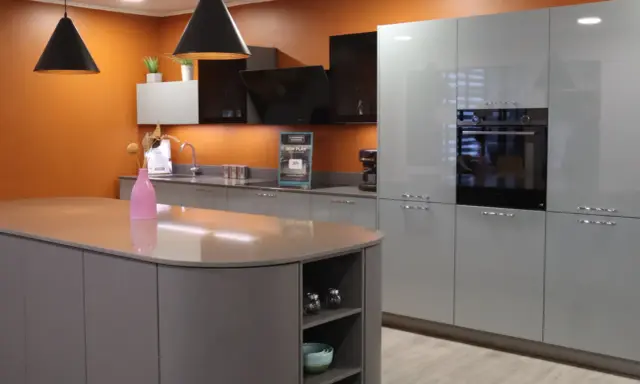 Aménagement d'une cuisine moderne avec îlot central et meubles gris laqué. Une **conception cuisine 3D** qui inspire.