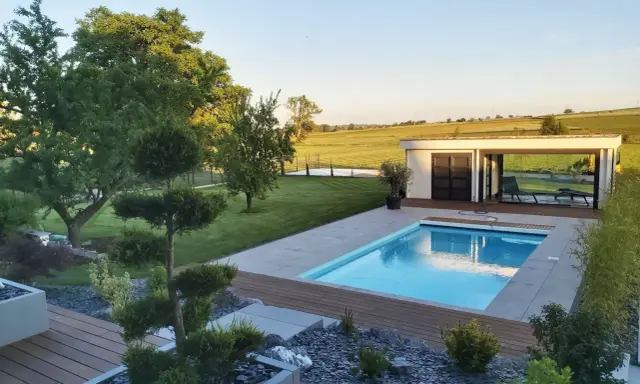 Magnifique jardin avec piscine, pelouse impeccable, arbres taillés et une petite maison moderne. Un havre de paix.