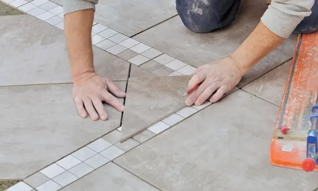 Mains expertes pour carreler une terrasse, posant une nouvelle dalle avec précision.