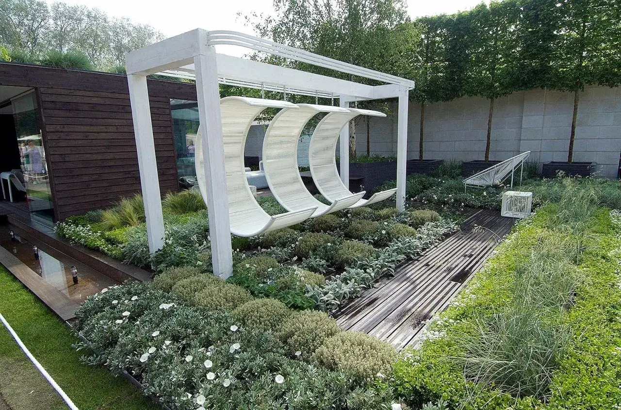 Jardinière de terrasse moderne avec balancelles suspendues, allée en bois et végétation luxuriante. Une idée pour un espace extérieur relaxant.