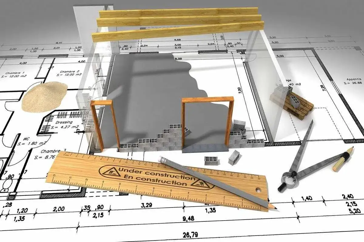 Plans de maison en cours de construction, avec des briques, du bois et des outils. Idéal pour un projet de rénover ma maison.