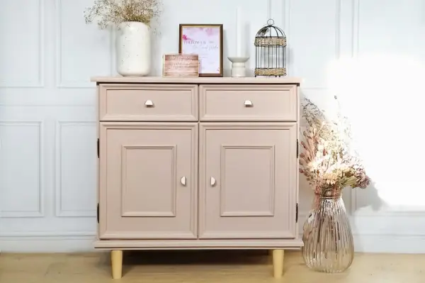 Meuble en bois repeint en rose poudré, une belle idée de couleur pour un relooking. Décoré avec des fleurs séchées et des cadres.