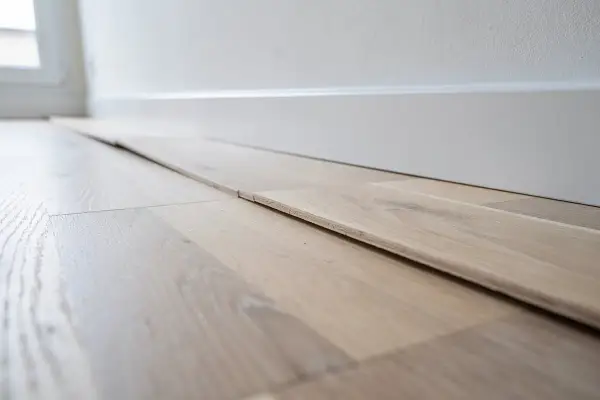 Planches de parquet gondolé, prêtes à être posées. On dirait qu'un fer à repasser a été utilisé pour les aplatir.