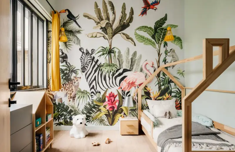 Une chambre d'enfant avec un mur jungle : zèbre, flamant rose, léopard, singe, toucan. Une excellente idée déco chambre enfant pour l'aventure !